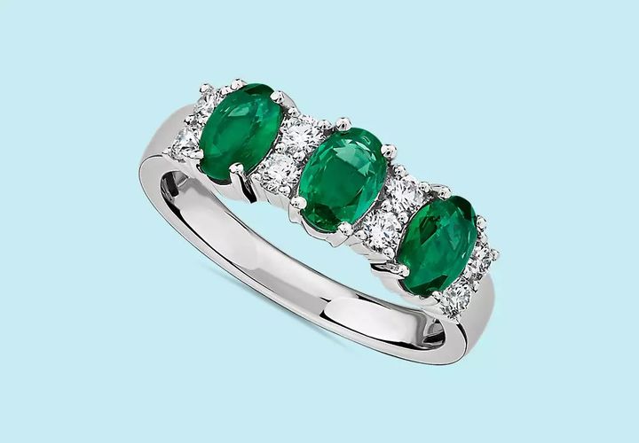 3 oval cut emerald gemstones mix with diamonds in a white gold ring